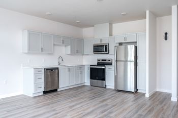 a kitchen with white cabinets and stainless steel appliances